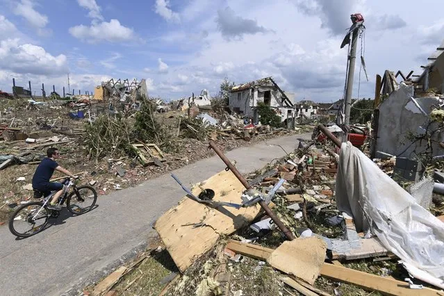 Man rides his bike after a tornado hit the village of Mikulcice in the Hodonin district, South Moravia, Czech Republic, Friday, June 25, 2021. A rare tornado tore through southeastern Czech Republic, killing a few people and injuring hundreds, rescue services said on Friday. (Photo by Ondrej Deml/CTK via AP Photo)