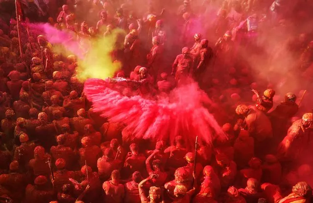 Hindu devotees take part in the religious festival of Holi inside a temple in Nandgaon village, in the state of Uttar Pradesh, India, March 12, 2022. (Photo by Adnan Abidi/Reuters)