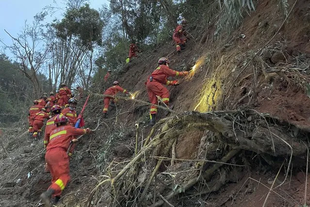 In this photo released by Xinhua News Agency, rescuers conduct search operations at the site of a plane crash in Tengxian County in southern China's Guangxi Zhuang Autonomous Region, Tuesday, March 22, 2022. Mud-stained wallets. Bank cards. Official identity cards. Some of the personal effects of 132 lives presumed lost were lined up by rescue workers scouring a remote mountainside Tuesday for the wreckage of a China Eastern plane that one day earlier inexplicably fell from the sky and burst into a huge fireball. (Photo by Zhou Hua/Xinhua via AP Photo)