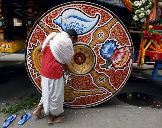 A Hindu devotee seeks blessings from the “Rath”, or the chariot of Lord Jagannath, during the annual Rath Yatra, or chariot procession, in Kolkata, India, July 18, 2015. (Photo by Rupak De Chowdhuri/Reuters)