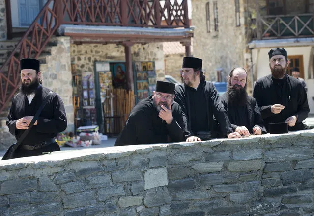 Orthodox monks look at the security preparations in the port of Dafni at Mount Athos, Greece, Friday, May 27, 2016. (Photo by Darko Bandic/AP Photo)