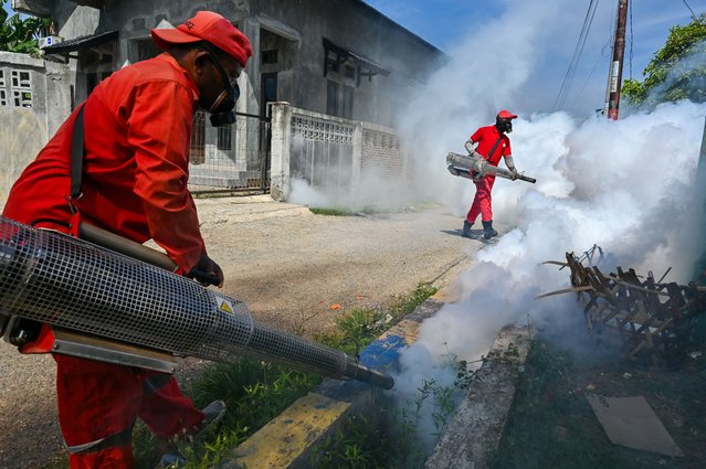 Workers dispense insecticide with fogging machines to kill mosquitoes spreading dengue fever in Banda Aceh on August 13, 2024. (Photo by Chaideer Mahyuddin/AFP Photo)