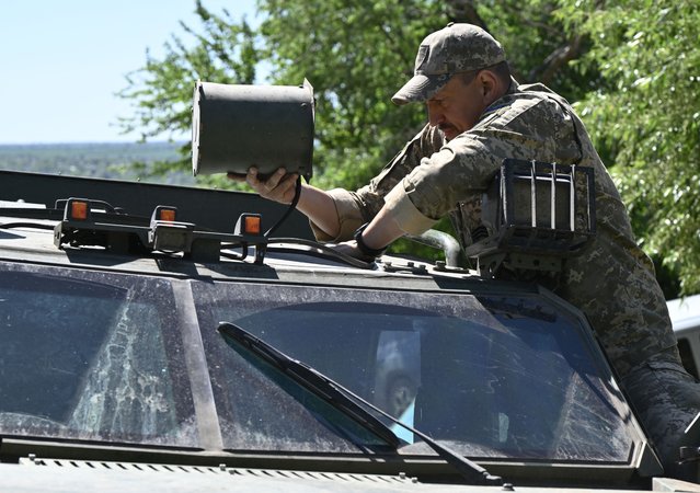 Ukrainian serviceman Mykola, 42, jammer specialist of the "Achilles" drone battalion of the 92nd assault brigade sets an antenna of a drone signal jamming system on an armored four-wheel-drive vehicle in an undisclosed location in the Donetsk region on April 30, 2024, amid the Russian invasion of Ukraine. (Photo by Genya Savilov/AFP Photo)