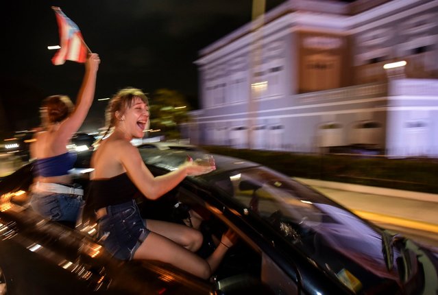 People celebrate after Gov. Ricardo Rossello announced that he is resigning Aug. 2 after weeks of protests over leaked obscene, misogynistic online chats, in San Juan, Puerto Rico, Thursday, July 25, 2019. (Photo by Carlos Giusti/AP Photo)