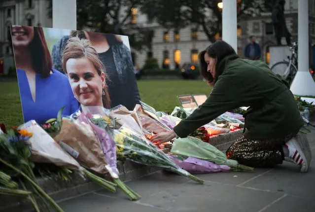 Floral tributes and candles are placed by a picture of slain Labour MP Jo Cox at a vigil in Parliament square in London on June 16, 2016. Cox died today after a shock daylight street attack, throwing campaigning for the referendum on Britain's membership of the European Union into disarray just a week before the crucial vote. (Photo by Daniel Leal-Olivas/AFP Photo)