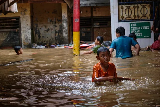 Indonesian children wade in their flooded neighborhood on January 2, 2020 in Jakarta, Indonesia. Flooding caused by heavy rain left at least 17 people dead and tens of thousands displaced from their homes as the city prepares for continued rains. (Photo by Ed Wray/Getty Images)