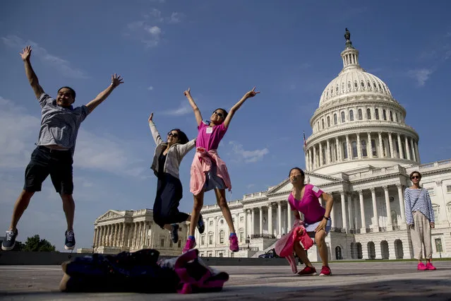 Tourists pose for a photograph in front of the Capitol Building in Washington, Monday, July 17, 2017. The Senate has been forced to put the republican's health care bill on hold for as much as two weeks until Sen. John McCain, R-Ariz., can return from surgery. (Photo by Andrew Harnik/AP Photo)