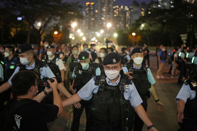 Police officers stop people entering the Hong Kong's Victoria Park, Saturday, June 4, 2022. Heavy police force patrolled Hong Kong's Victoria Park on Saturday after authorities for a third consecutive year banned public commemoration of the anniversary of the deadly Tiananmen Square crackdown in 1989, with vigils overseas the only place marking the event. (Photo by Kin Cheung/AP Photo)
