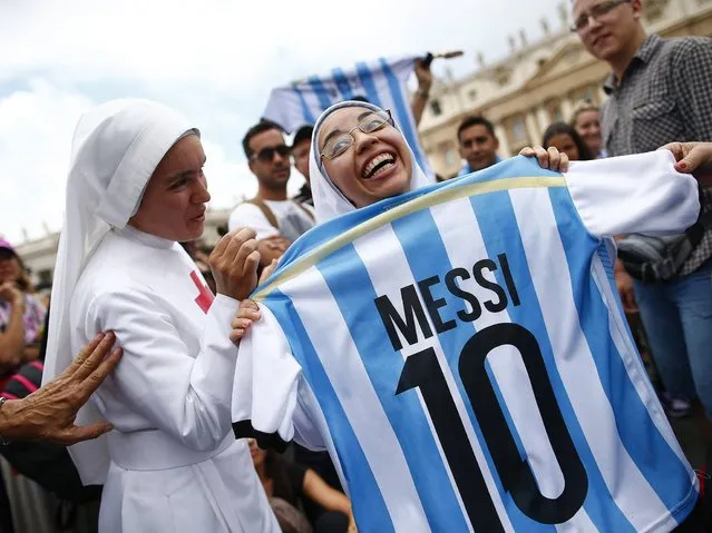 A nun holds an Argentinian national soccer team jersey as she waits for Pope Francis' Sunday Angelus prayer in Saint Peter's square at the Vatican, on Jule 13, 2014. (Photo by Tony Gentile/Reuters)