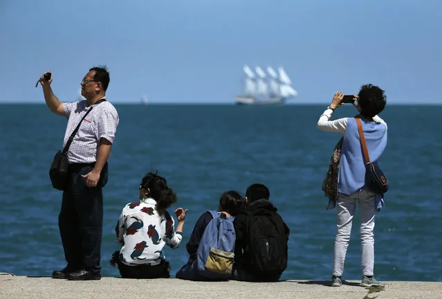 In this photo taken Wednesday, June 29, 2016, tourists photograph along Chicago's Lake Michigan waterfront and near the site where George Lucas wanted to build his Star Wars museum in Chicago. Friends of the Parks Director Juanita Irizarry led the obscure nonprofit that stood its ground and blocked Lucas' private museum from being built on Chicago's prized lakefront. (Photo by Charles Rex Arbogast/AP Photo)