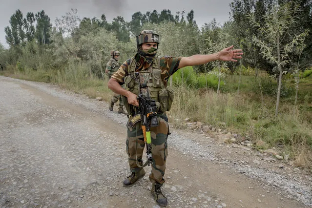 An Indian army soldier orders journalists to move away near the site of a  in Pulwama, about 35 Kilometers south of Srinagar, Indian controlled Kashmir, Saturday, August 26, 2017. At least two gunmen entered a police camp in southern Pulwama town firing guns and grenades at the sentry, said Director-General of police S.P. Vaid. (Photo by Dar Yasin/AP Photo)