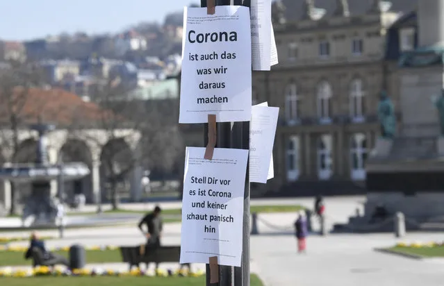 A picture taken on march 18, 2020 shows placards reading “Corona is also what we do out of it” (top) and “Imagine this is Corona and nobody looks at it panickly” on a pole in Stuttgart, southern Germany, on March 18, 2020. German Chancellor will for the first time deliver a televised address to German citizens on the escalating coronavirus crisis on March 18, 2020 in the evening. (Photo by Thomas Kienzle/AFP Photo)