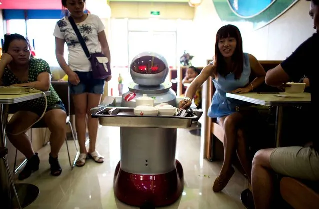This photo taken on August 13, 2014, shows a robot carrying food to customers in a restaurant in Kunshan.  (Photo by Johannes Eisele/AFP Photo)