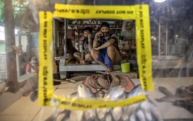 Vendors rest in their stall covered in plastic to enforce social distancing on March 30, 2020 in Las Pinas, Metro Manila, Philippines. The Philippine government has sealed off Luzon, the country's largest and most populous island, to prevent the spread of COVID-19. Land, sea, and air travel has been suspended, while government work, schools, businesses, and public transportation have been ordered shut in a bid to keep some 55 million people at home. The Philippines' Department of Health has so far confirmed 1418 cases of the new coronavirus in the country, with at least 71 recorded fatalities. (Photo by Ezra Acayan/Getty Images)