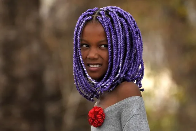 Sophia Fernandes, a member of the Kalunga quilombo, the descendants of runaway slaves, dons traditional afro braids, during the culmination of the week-long pilgrimage and celebration for the patron saint “Nossa Senhora da Abadia” or Our Lady of Abadia, in the rural area of Cavalcante in Goias state, Brazil, Saturday, August 13, 2022.  Devotees celebrate Our Lady of Abadia at this time of the year with weddings, baptisms and by crowning distinguished community members, as they maintain cultural practices originating from Africa that mix with Catholic traditions. (Photo by Eraldo Peres/AP Photo)