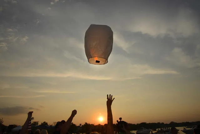 A sky lantern is released during a vigil at Lakefront Park to honor Lt. Charles Joseph Gliniewicz, Wednesday, September 2, 2015, in Fox Lake, Ill. Gliniewicz was shot and killed Tuesday while pursuing a group of suspicious men. Authorities broadened the hunt Wednesday for the suspects wanted in the fatal shooting. (Photo by John Starks/Daily Herald via AP Photo)