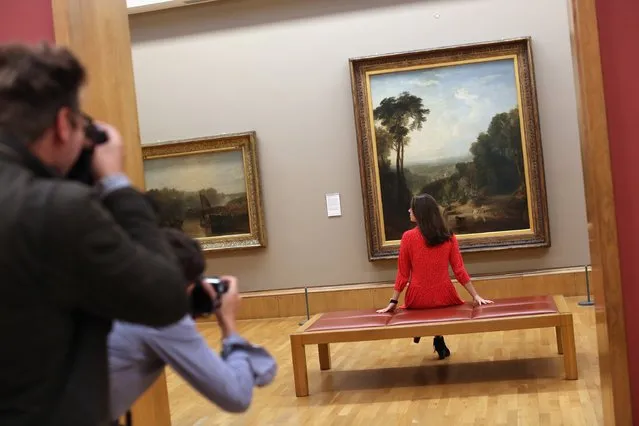 A press officer poses in a gallery space in front of a painting entitled “Crossing the Brook” by Joseph Turner during a photocall at the Tate Britain on August 3, 2016 in London, England. The photocall was to promote the fact that paintings by British artist Joseph Mallord William Turner, have been returned to the gallery after being exhibited elsewhere. The exhibition features 100 key works and runs at the Clore Gallery. (Photo by Dan Kitwood/Getty Images)