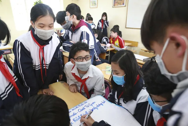 Students wear masks in during class at the Dinh Cong secondary school in Hanoi, Vietnam on January 31, 2020. The authorities have advised students to wear masks to school, a day after Vietnam confirmed three more cases of the new virus. (Photo by Hau Dinh/AP Photo)