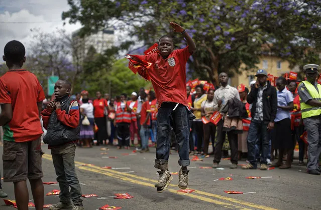 A Kenyan child dances to the music playing as supporters of President Uhuru Kenyatta await his arrival for an event at City Hall in downtown Nairobi, Kenya Monday, October 23, 2017. Kenyatta said Monday the presidential election must go ahead as planned on Thursday, despite a boycott by the main opposition candidate and the chief electoral officer's recent statement that he cannot guarantee that the polls would be credible. (Photo by Ben Curtis/AP Photo)