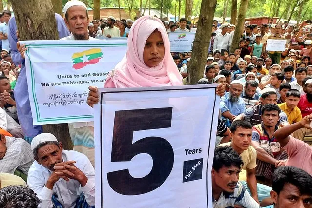 Rohingya refugees hold placards as they gather at the Kutupalong Refugee Camp to mark the fifth anniversary of their fleeing from neighbouring Myanmar to escape a military crackdown in 2017, in Cox's Bazar, Bangladesh, August 25, 2022. (Photo by Rafiqur Rahman/Reuters)