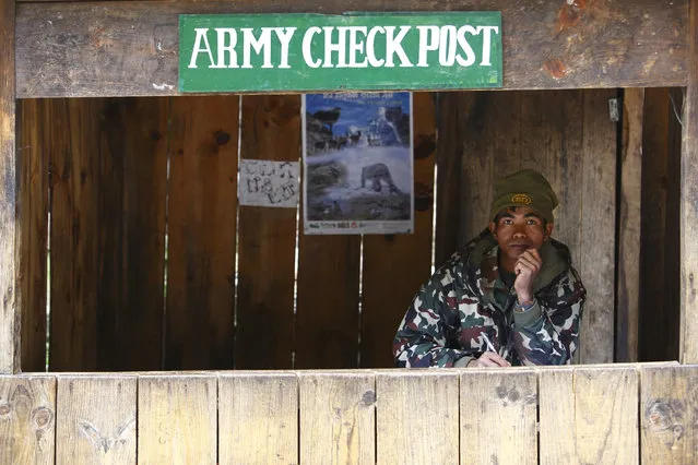 A Nepalese army personnel sits inside a check post as he waits to check permits for trekkers passing by, in Solukhumbu District April 26, 2014. (Photo by Navesh Chitrakar/Reuters)