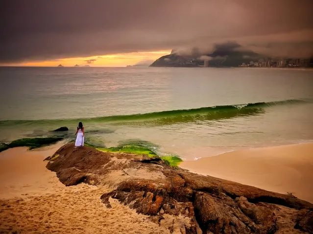 Ipanema Beach, Rio de Janeiro. “A rainy day in Rio and nobody goes out! Of course, I love rainy-day light because I know special things can happen. I went to Ipanema with my assistant and she went out on to Arpoador rock. The rain let up for a bit, and the magic light gave us this colour palette”. (Photo by David Alan Harvey/The Guardian)