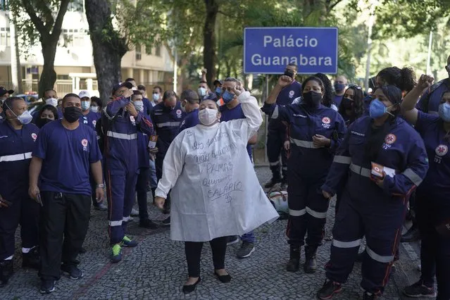 An emergency health worker raises her fist as she takes part in a protest demanding payment of salaries and an improvement in benefits amid the new coronavirus pandemic, outside Guanabara Palace, the seat of state government in Rio de Janeiro, Brazil, Saturday, June 20, 2020. Brazil's government confirmed that the country has risen above 1 million confirmed COVID-19 cases, second only to the United States. (Photo by Leo Correa/AP Photo)