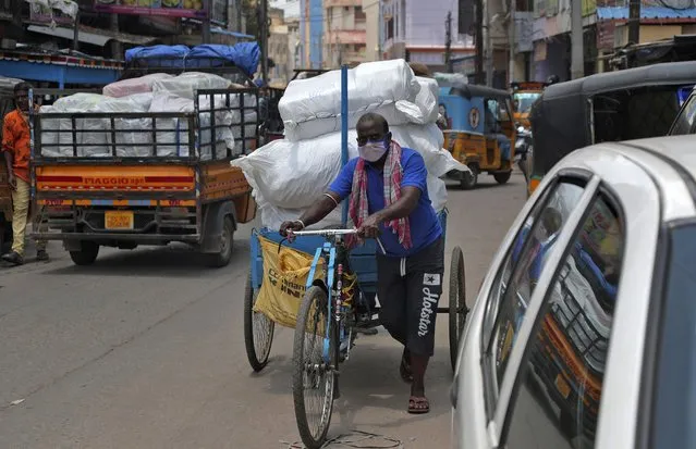 An Indian cycle rickshaw puller wearing face mask transports a load in Hyderabad, India, Thursday, June 25, 2020. India is the fourth hardest-hit country by the pandemic in the world after the U.S., Russia and Brazil. (Photo by Mahesh Kumar A./AP Photo)