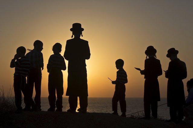 Jewish worshippers take part in the Tashlich ritual on the shore of the Mediterranean Sea in Herzliya, near Tel Aviv September 21, 2015, ahead of Yom Kippur, the Jewish Day of Atonement, which starts at sundown Friday. Tashlich is a ritual of casting away sins of the past year into the water. (Photo by Nir Elias/Reuters)