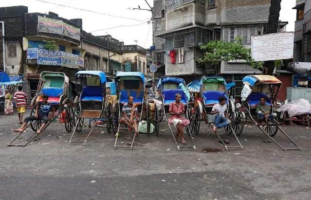 Hand-rickshaw pullers wait for customers along a roadside in Kolkata, India, August 22, 2016. (Photo by Rupak De Chowdhuri/Reuters)