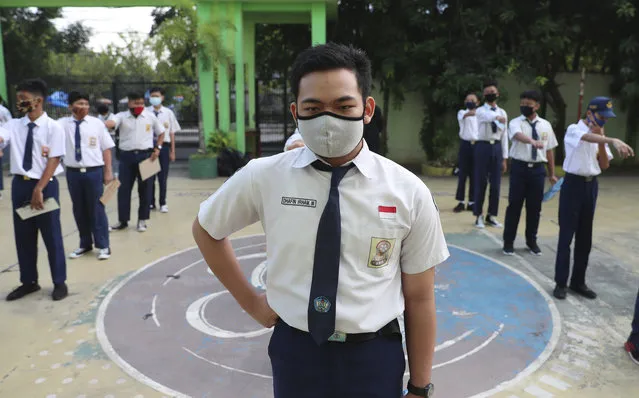 Students wearing face masks as a precaution against the new coronavirus line up at their school during the first day of reopening of state high schools in Bekasi on the outskirts of Jakarta, Indonesia, July 13, 2020. (Photo by Achmad Ibrahim/AP Photo)