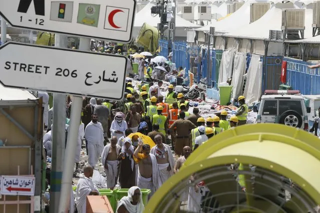 Muslim pilgrims and rescue workers gather around the victims of a stampede in Mina, Saudi Arabia during the annual hajj pilgrimage on Thursday, September 24, 2015. (Photo by AP Photo)