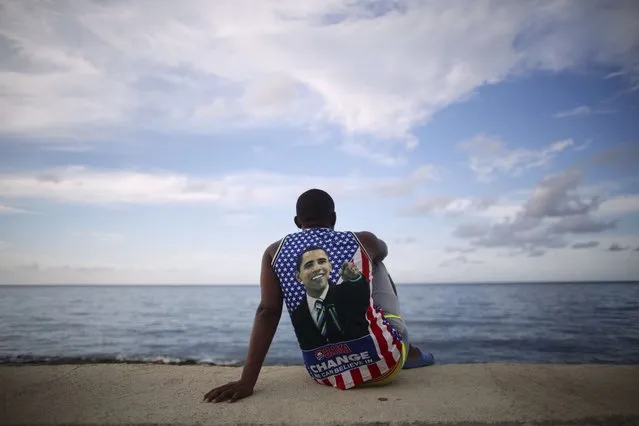 Medical student Electo Rossel, 20, wearing a shirt with a picture of U.S. President Barack Obama, listens to music at the Malecon seafront outside the U.S. embassy (not pictured) in Havana, Cuba, in this file photo taken August 14, 2015. (Photo by Alexandre Meneghini/Reuters)