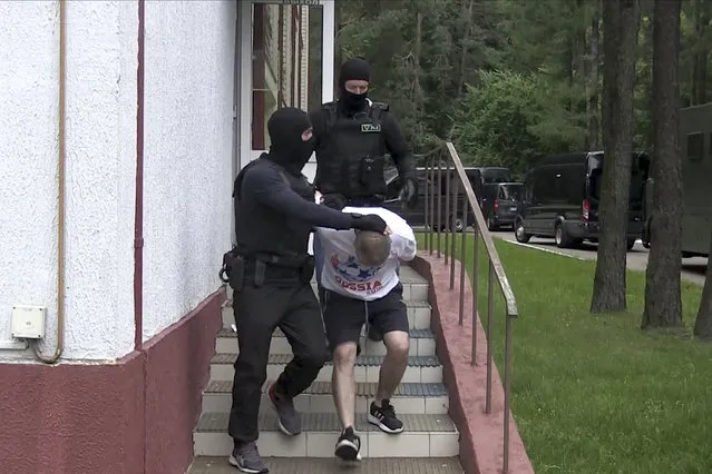 In this photo taken from video released by Belarusian KGB, State TV and Radio Company of Belarus on Wednesday, July 29, 2020, a Belarusian KGB officer detains a Russian man in a sanitarium outside in Minsk, Belarus. Belarusian officials said that more than 30 detained employees of private Russian military contractor Wagner are facing a criminal probe on charges of plotting terror attacks in Belarus amid a presidential election campaign. (Photo by Belarusian KGB, State TV and Radio Company of Belarus via AP Photo)