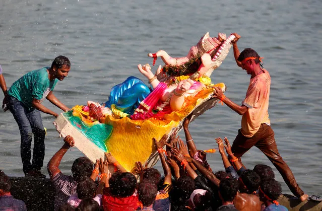 Devotees immerse an idol of the Hindu god Ganesh, the deity of prosperity, in the Sabarmati river during the 10-day-long Ganesh Chaturthi festival in Ahmedabad, India, September 11, 2016. (Photo by Amit Dave/Reuters)