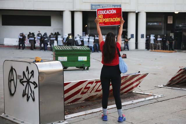 A demonstrator holds a placard in front of the police as protesters gather around the Los Angeles Federal Building following multiple detentions by Immigration and Customs Enforcement (ICE), in downtown Los Angeles, California, U.S., June 6, 2025. (Photo by Daniel Cole/Reuters)