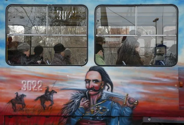 People ride a tram with a painting depicting a Ukrainian Cossack in Donetsk, November 10, 2014. (Photo by Maxim Zmeyev/Reuters)