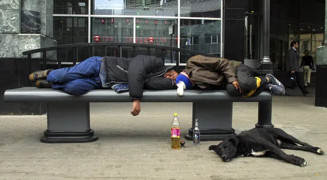In this September 2005 file photo, unidentified men sleep with bottles of drink near-at-hand, on a bench in Moscow. Some Russian officials this week are daring to think the seemingly unthinkable in the land of vodka – banning the sale of alcohol once a week in the country's two main cities. (Photo by Alexei Sazonov/AP Photo)