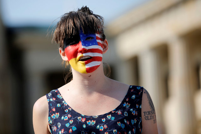 A campaigner with a American and German flag painted on her face stands in front of the Brandenburg Gate to urge Americans living abroad to register and vote in Berlin, Germany, September 23, 2016. (Photo by Axel Schmidt/Reuters)