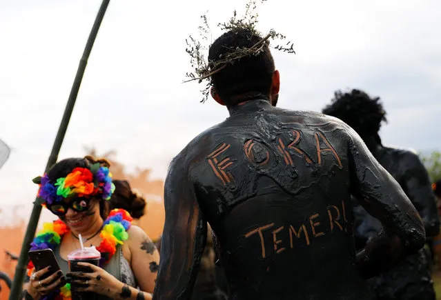 A festivalgoer has “Out Temer” written on his back in reference to Brazil’s president during a carnival festivities in Paraty, Brazil February 10, 2018. (Photo by Nacho Doce/Reuters)