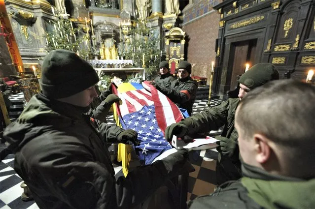 Ukrainians soldiers participate in the farewell ceremony for US citizen Daniel W. Swift in Lviv, Ukraine, Tuesday, January 31, 2023. A former US Navy SEAL who went AWOL in 2019, Swift was killed last week in Ukraine in fighting with the Russian army. (Photo by Mateusz Nowak/AP Photo)