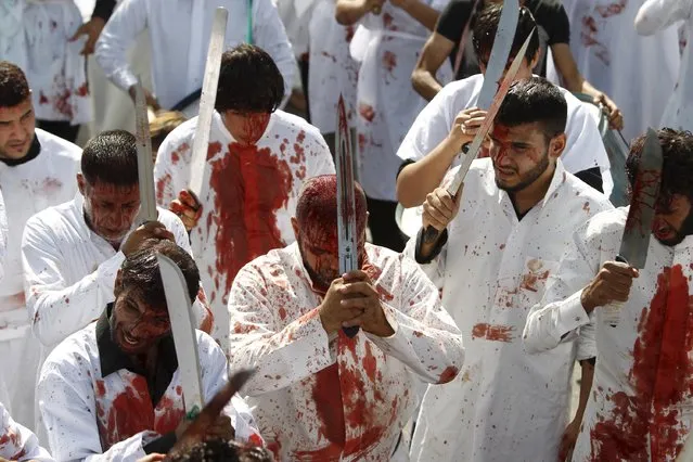 Iraq Shi'ite Muslim men bleed as they gash their foreheads with swords and beat themselves while commemorating Ashura in Baghdad, October 24, 2015. (Photo by Ahmed Saad/Reuters)