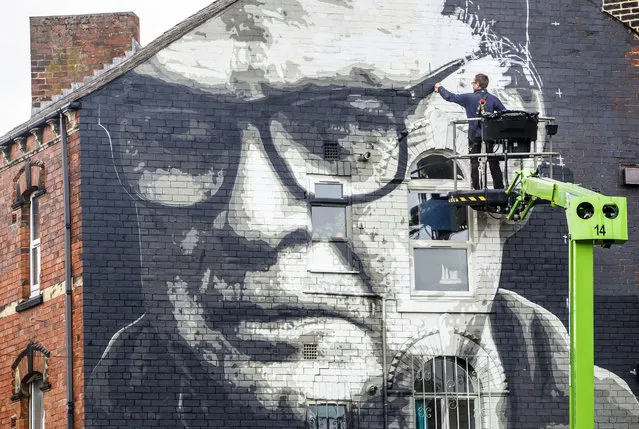 Artist Irek Jasutowicz works on a new mural of Leeds United soccer team manager Marcelo Bielsa near Hyde Park in Leeds, England Thursday September 10, 2020. The West Yorkshire club will mark their return to the English Premier League after a 16-year wait with a trip to champions Liverpool on Saturday. (Photo by Danny Lawson/PA Wire via AP Photo)