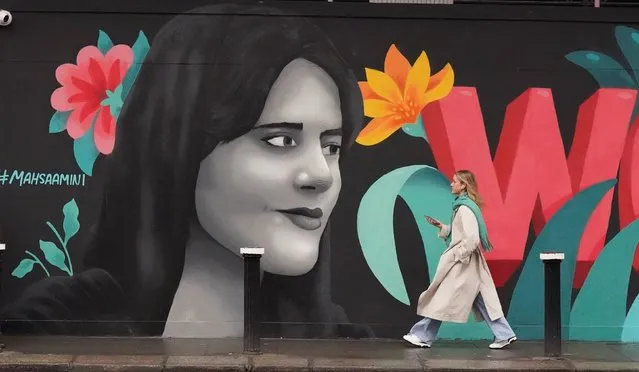 People walk past a mural highlighting the plight of women in Iran, on Dame Street in Dublin on Monday, January 23, 2023. The Mural, by group of female artists known as the Minaw Collective, has the words “Woman Life Freedom” in English, Irish and Persian, and features an image of 22-year-old Masha Amini. Protests erupted in Iran in mid-September following the death of Ms Amini, who died after being arrested by Iran's morality police for allegedly violating the Islamic Republic's strict dress code. Hundreds of people have been killed and thousands arrested during demonstrations over the circumstances of her death. (Photo by Niall Carson/PA Images via Getty Images)