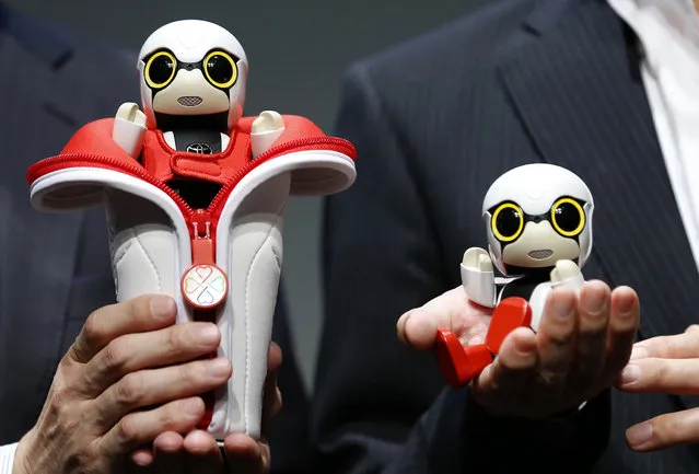 In this September 27, 2016 photo, Toyota Motor Corp. SMO Moritaka Yoshida, right, and Fuminori Kataoka, project general manager from Toyota Motor Corp., pose for photographers with compact sized humanoid communication robots, Kirobo Mini, during a press unveiling in Tokyo. The new robot from Japanese automaker Toyota Motor Corp. can’t do much else but chatter in a high-pitched voice. (Photo by Shizuo Kambayashi/AP Photo)