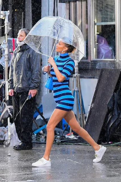 American model Bella Hadid sheltered from a rainstorm under a see-through umbrella in New York City on October 18, 2020. The model was shooting for Michael Kors. (Photo by Backgrid USA)