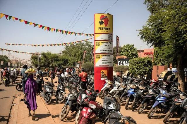 Motorcycles are parked in front of the headquarters of the FESPACO (Pan-African Film and Television Festival) in Ouagadougou, Burkina Faso, Friday, February 24, 2023. Most film festivals can be counted on to provide entertainment, laced with some introspection. The weeklong FESPACO that opens Saturday in violence-torn Burkina Faso's capital goes beyond that to also offer hope, and a symbol of endurance. (Photo by Sophie Garcia/AP Photo)