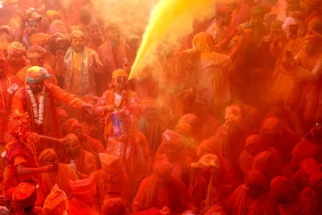 In this photograph taken on February 27, 2023, devotees smear with colours as they celebrate Hindu spring festival of Holi at Shreeji temple in Barsana, Mathura district. (Photo by AFP Photo/Stringer)