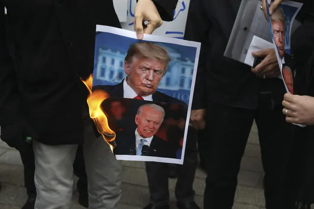 A group of protesters burn pictures of the U.S. President Donald Trump, top, and the President-elect Joe Biden in a gathering in front of Iranian Foreign Ministry on Saturday, November 28, 2020, a day after the killing of Mohsen Fakhrizadeh an Iranian scientist linked to the country's nuclear program by unknown assailants near Tehran. (Photo by Vahid Salemi/AP Photo)