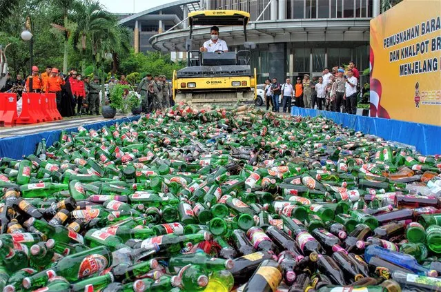 Thousands of bottles of alcoholic beverages are destroyed in Pekanbaru on March 21, 2023, ahead of the Muslim holy month of Ramadan. (Photo by Wahyudi/AFP Photo)